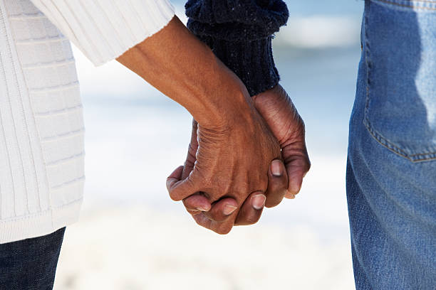 Close Up Of Senior Couple Holding Hands On Beach Close Up Of Senior Couple Holding Hands On Beach